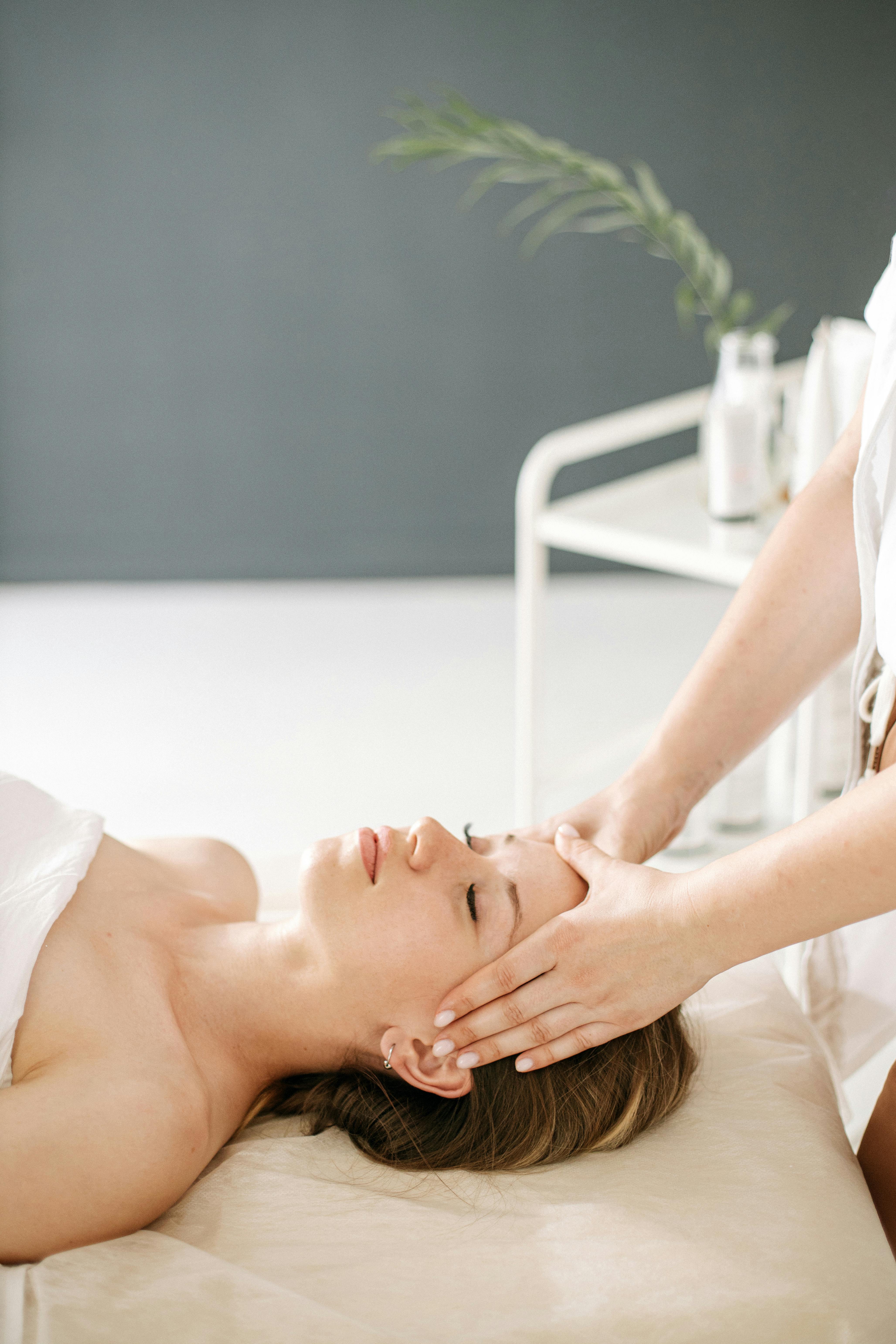Therapist giving relaxing face massage