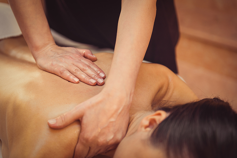 Therapist working along a guest's back during a massage